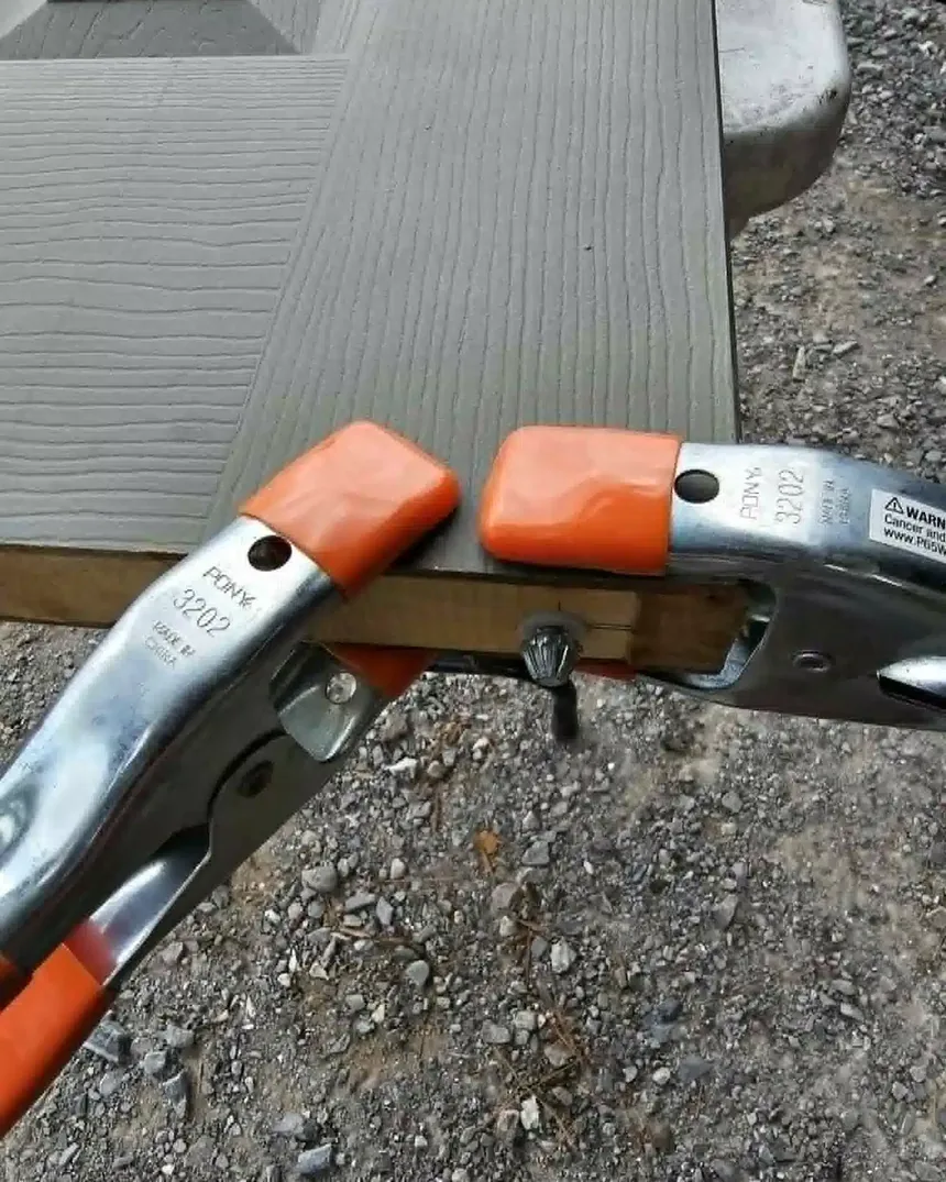 Trim board held in a mitre clamp during finish carpentry