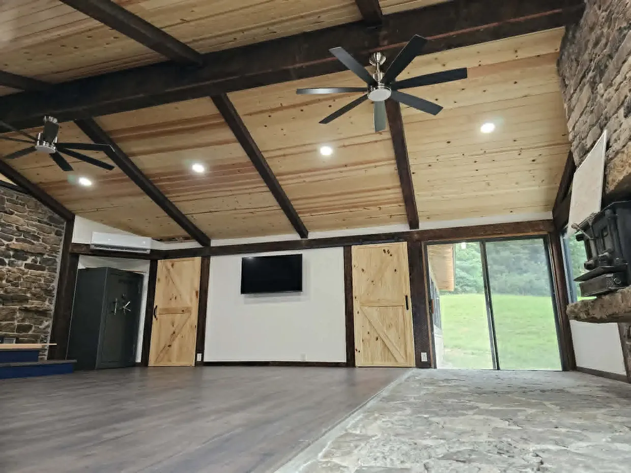Great room with wood plank ceiling, exposed beams and stone fireplace
