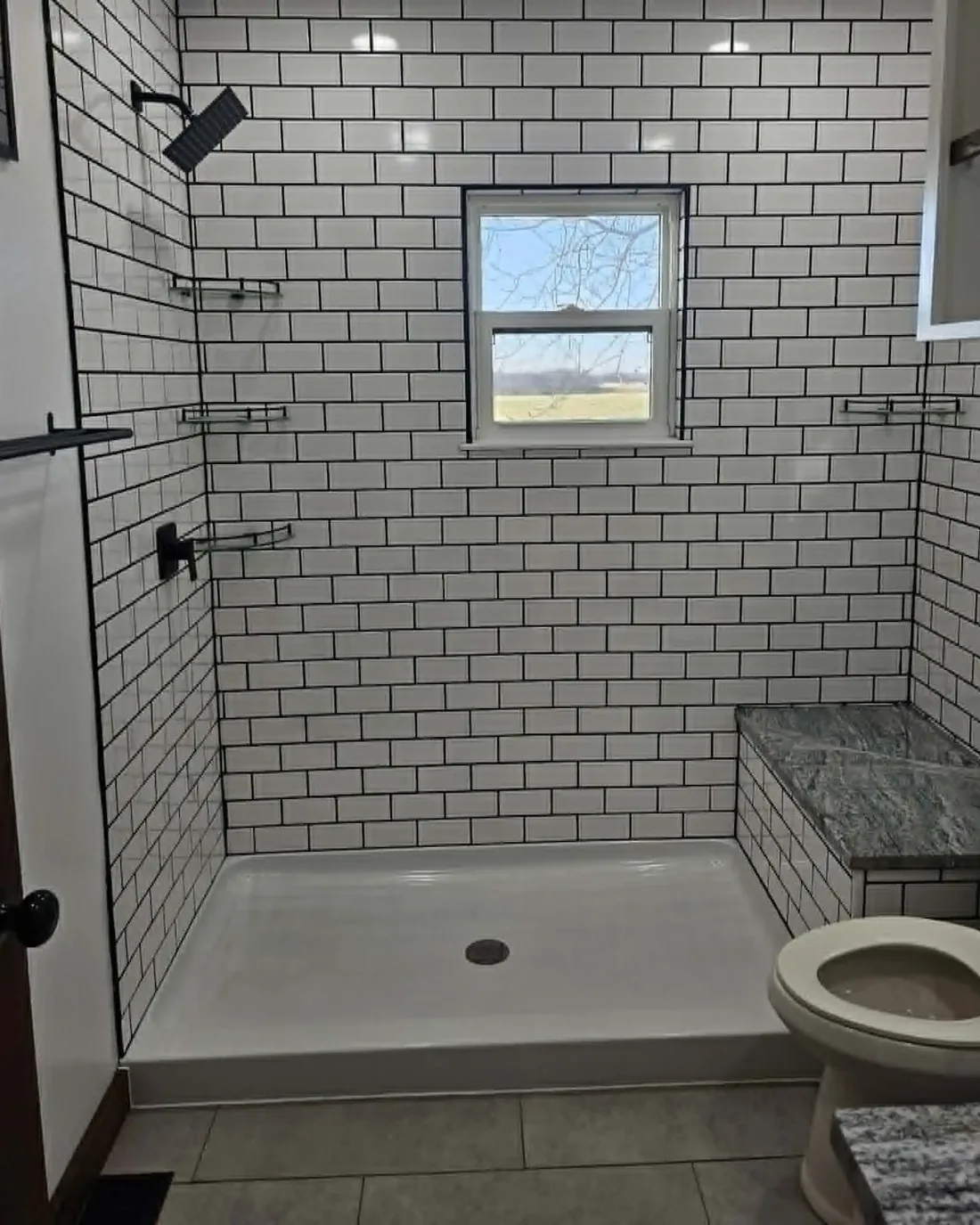 Finished bathroom with white subway tile shower and built-in bench